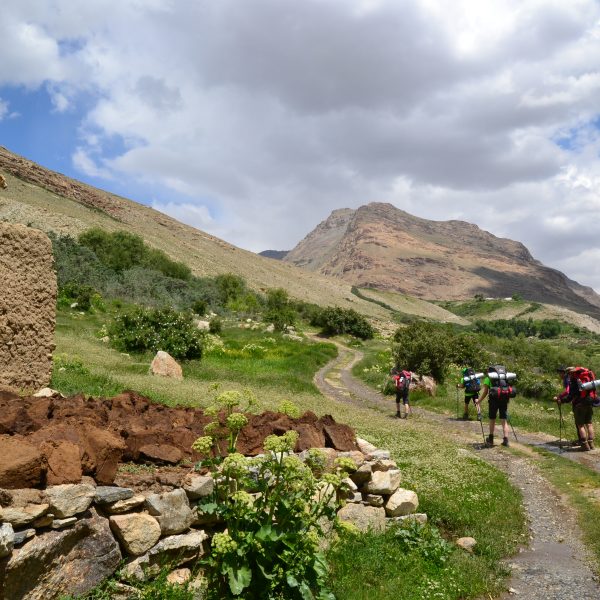 dans la montagne des femmes marchent de dos pres d'un village