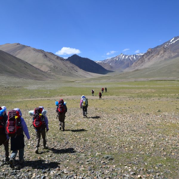trekkeurs marchent dans la montagne aride avec des gros sacs à dos